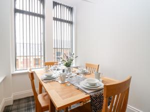 a dining room with a table and chairs and windows at The Court Room at The Institute Executive Apartments in Keith