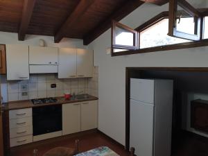 uma cozinha com armários brancos e um frigorífico branco em Appartamento Rosy em Fiumalbo
