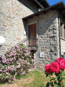 um edifício de pedra com flores em frente a uma porta em Appartamento Rosy em Fiumalbo