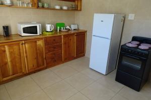 a kitchen with a white refrigerator and a microwave at Lovely 2-bedroom apartment with free parking on premises in Jeffreys Bay