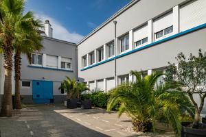 a building with palm trees in front of it at Smartappart Lorient in Lorient