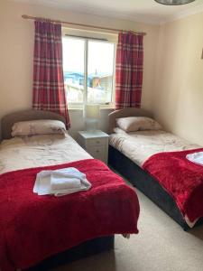 a bedroom with two beds and a window at Welcoming House in Portree Isle of Sky Scotland in Portree