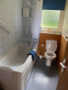 a bathroom with a white tub and a toilet at Welcoming House in Portree Isle of Sky Scotland in Portree