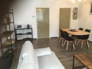 een woonkamer met een witte bank en een tafel bij Residentie Jan Bart in Oostende