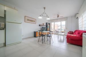 ein Wohnzimmer mit einem roten Sofa und einem Tisch in der Unterkunft HomeHolidaysRentals Margot - Costa Barcelona in Pineda de Mar