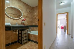 ein Badezimmer mit Waschbecken, Badewanne und Spiegel in der Unterkunft HomeHolidaysRentals Margot - Costa Barcelona in Pineda de Mar
