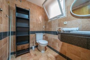 ein Badezimmer mit Toilette, Waschbecken und Spiegel in der Unterkunft HomeHolidaysRentals Margot - Costa Barcelona in Pineda de Mar + 14 Fotos