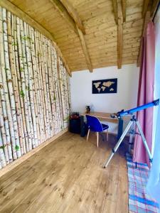 een kamer met een bureau en een stoel in een kamer met houtblokken bij Intense Room in Remeţi