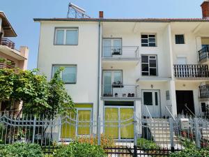 um edifício de apartamentos branco com uma cerca em frente em Eli&Kire's Home em Bitola