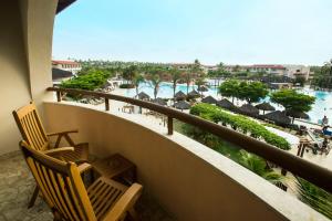 a balcony with two chairs and a view of a resort at Grand Palladium Imbassaí Resort & Spa - All Inclusive in Imbassai