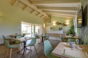 um restaurante com mesas de madeira e cadeiras verdes em Terra Fina em Savio di Ravenna