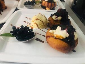 a plate of food with pastries and ice cream and blackberries at Intense Room in Remeţi