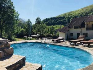 a large swimming pool with a patio and a house at Intense Room in Remeţi