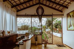 Habitación con ventana grande y mesa con sillas. en Pousada Casa de Shiva en Alto Paraíso de Goiás