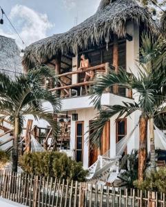 a man sitting on the balcony of a house at Casitas Pacific in Popoyo