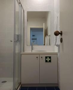 W łazience znajduje się umywalka oraz prysznic z lustrem. w obiekcie Apartamentos Ázera - Lígia Ázera w mieście Praia da Vitória