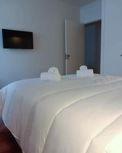 białe łóżko z dwoma ręcznikami na górze w obiekcie Apartamentos Ázera - Lígia Ázera w mieście Praia da Vitória