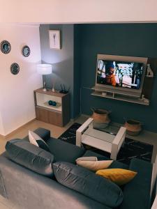 a living room with a couch and a tv at Patio San Ignacio in San Juan
