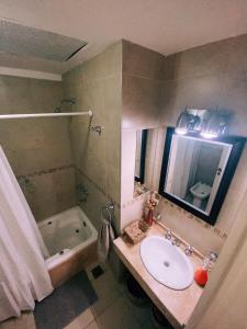 a bathroom with a sink and a tub and a mirror at Patio San Ignacio in San Juan