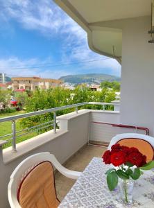 a table with a vase of red roses on a balcony at Apartments Ela in Ulcinj