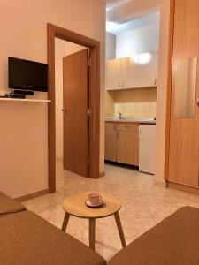 a living room with a table and a kitchen at Apartments Ela in Ulcinj