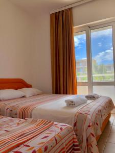 two beds in a room with a window at Apartments Ela in Ulcinj