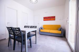 a dining room with a table and chairs and a couch at Donnosanto Residence Pantanagianni in Torre Santa Sabina