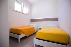 a bedroom with two beds and a window at Donnosanto Residence Pantanagianni in Torre Santa Sabina