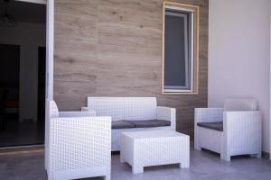 a group of white chairs and a table at Donnosanto Residence Pantanagianni in Torre Santa Sabina