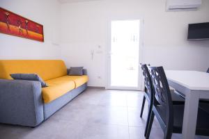 een woonkamer met een gele bank en een tafel bij Donnosanto Residence Pantanagianni in Torre Santa Sabina