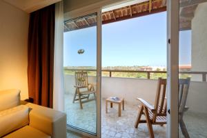 a living room with a couch and a balcony at Grand Palladium Imbassaí Resort & Spa - All Inclusive in Imbassai