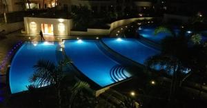 a large swimming pool at night with lights at Kilua Beach Resort in Mombasa