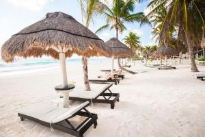 una fila de sillas y sombrillas en una playa en Kilua Beach Resort, en Mombasa
