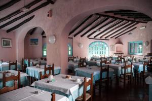 サン・テオドーロにあるHotel Scintillaのテーブルと椅子が備わるレストラン