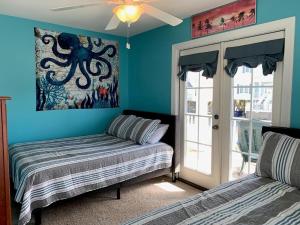 a bedroom with a bed and an octopus painting on the wall at 2 the C in Holden Beach +38 photos