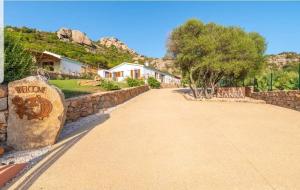 a house with a stone wall and a driveway at Tenuta Petra Manna in Palau
