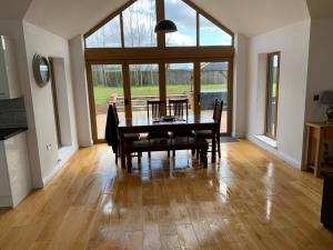 Un comedor con mesa y sillas y una gran ventana. en Chestnut-Lodge is rural, secluded, private with Hot Tub, en Maidstone 23 fotos más
