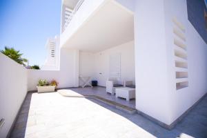 a white house with white walls and a patio at Donnosanto Residence Pantanagianni in Torre Santa Sabina