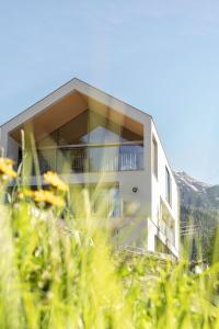 a building on a hill with plants in the foreground at Omaela Apartments in Sankt Anton am Arlberg