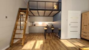 Il comprend une cuisine et une salle à manger avec une échelle loft. dans l'établissement Apartament Parkowy Antresola, à Gniezno
