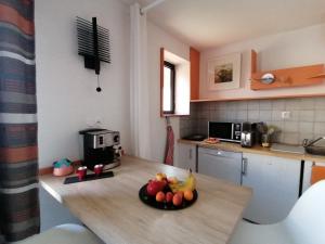 a kitchen with a bowl of fruit on a counter at ORION - COSYNEST à Toulouse Blagnac - pkg privé & climatisation in Blagnac