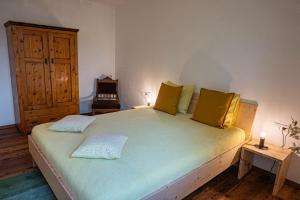 a bedroom with a large bed with yellow pillows at Haus18. 4 in Sluderno +16 photos