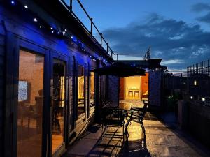 a patio with a table and an umbrella on a building at Home from Home - IONA - Private Members Club in Edinburgh