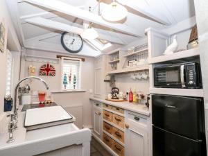 a kitchen with white cabinets and a clock on the ceiling at The Mouse House in Elton