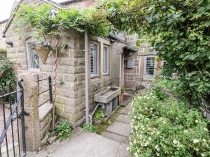 an old stone house with a bench on the side of it at The Mouse House in Elton