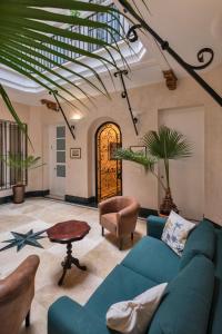 sala de estar con sofá azul y mesa en Gadir Suites en Cádiz