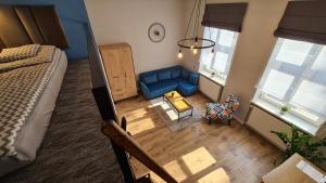 an overhead view of a living room with a blue couch at Antresola - Apartamenty Parkowe in Gniezno