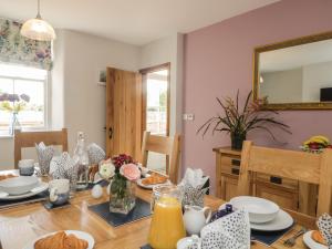 a dining room with a table and a mirror at Carrock Cottage in Dalston