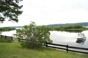 a boat sitting in the water next to a fence at Odin Camping AS in Svensrud