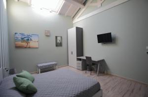 a bedroom with a bed and a desk and a television at La CASA DEGLI ARTISTI in Tuscania